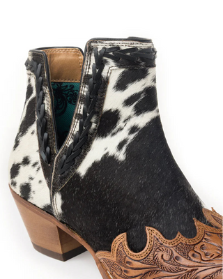 Black and white cowhide leather boot with brown heel and decorative sole on a white background
