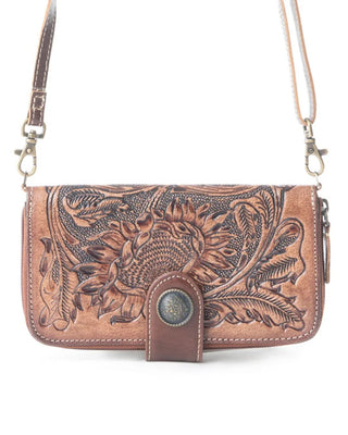 A brown tooled leather crossbody bag with floral and sunflower designs, featuring a snap-button closure and a matching leather strap on a white background.