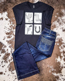 The Four Aces Graphic Tee displayed on cowhide along with jeans.