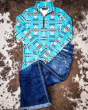The Laramie Kreek Fitted Pullover displayed on cowhide along with jeans.