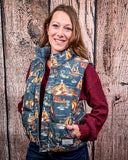A girl wearing the Jolie Hooey Reversible Puffer Vest. She has both hands in her pockets. She is standing in front of a wood backdrop.