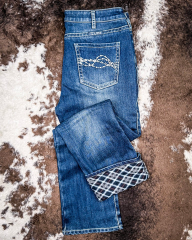 Denim Flannel Jeans laying on a cowhide rug 
