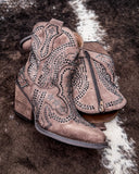 Brown faux suede ankle boots with decorative studs on a textured surface
