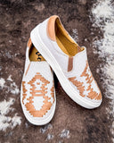 White slip-on sneakers with brown pattern on a textured surface