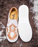White slip-on shoes with brown geometric pattern on a textured surface
