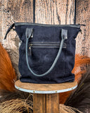 Black leather handbag on a wooden stool with a rustic background