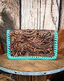 Leather wallet with turquoise edge on a wooden surface