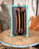 Turquoise-rimmed wallet with brown interior on a wooden surface