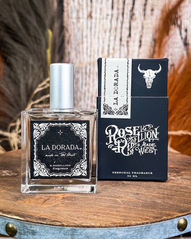 La Dorada perfume bottle and packaging on a wooden surface with a rustic background