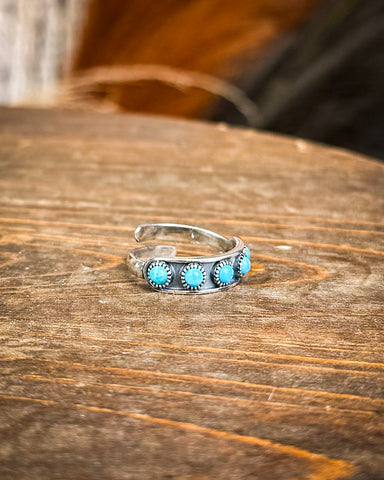 Hachi Adjustable Genuine Turquoise Ring displayed on wooden table.