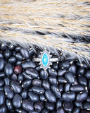 Turquoise Ring shown in black pebbles.