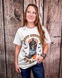 Woman wearing a 'Boot Scootn' Spooky' t-shirt against a wooden background