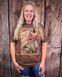 Person wearing a brown graphic t-shirt against a wooden background
