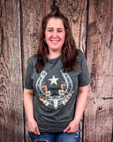 Woman wearing a gray t-shirt with a graphic design against a wooden background