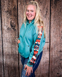 Person wearing a blue hoodie with colorful sleeves against a wooden background