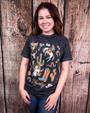 Person wearing a graphic t-shirt with cowboy design against a wooden background