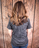 Person wearing a black t-shirt against a wooden background