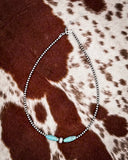 Necklace with turquoise beads on a cowhide background
