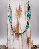 Necklace with turquoise and silver beads on a wooden surface