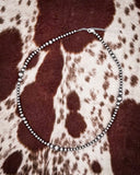 Necklace on a patterned fabric background