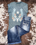 Grey graphic t-shirt with horseshoe design and jeans on a textured surface