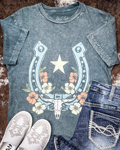 Grey graphic t-shirt with horseshoe design on a textured surface
