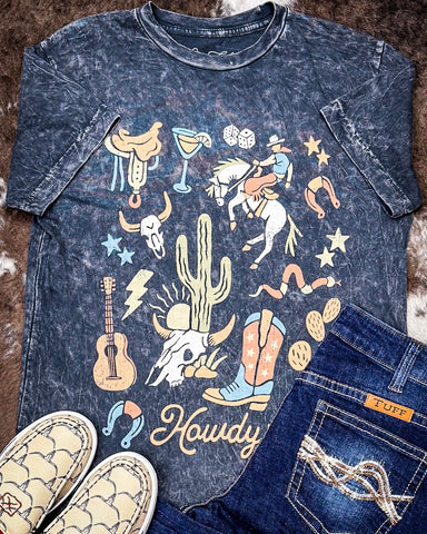 Black graphic t-shirt with western-themed design and jeans on a textured surface