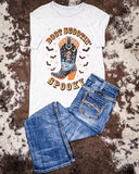 White t-shirt with 'Boot Scootin' Spooky' design and blue jeans on a cowhide rug background