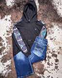 Black hoodie with patterned sleeves and blue jeans on a textured surface