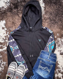 Black hoodie with patterned sleeves and jeans on a textured surface