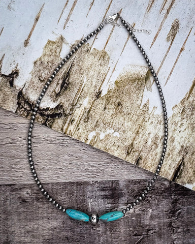 Necklace with turquoise accents on a wooden surface