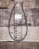 Necklace on a wooden surface with a ruler for scale