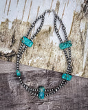 Necklace with turquoise stones on a rustic surface