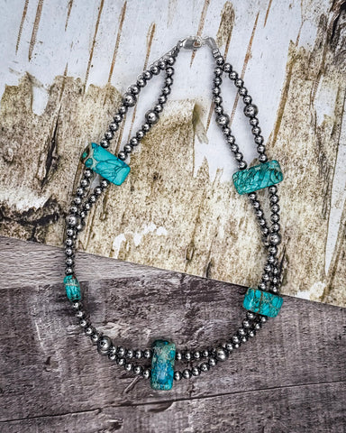 Necklace with turquoise stones on a rustic surface