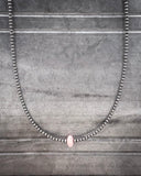 Necklace with pink conch on a gray textured background