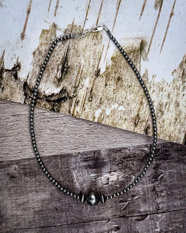 Beaded necklace on a wooden surface with a rustic background
