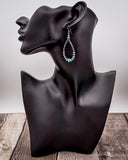 Earring displayed on a black mannequin bust against a neutral background
