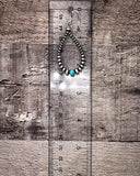 Pair of beaded earrings with turquoise stones on a wooden surface with a ruler for scale.