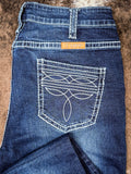 Blue jeans with a boot stitch on the back pocket against a brown background