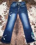 Blue jeans with decorative elements on a textured surface