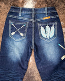 Blue jeans with feather and arrow designs on a brown surface