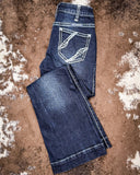 Folded pair of blue jeans on a textured brown surface