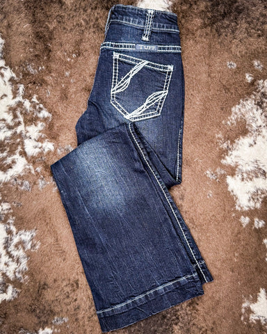 Folded pair of blue jeans on a textured brown surface