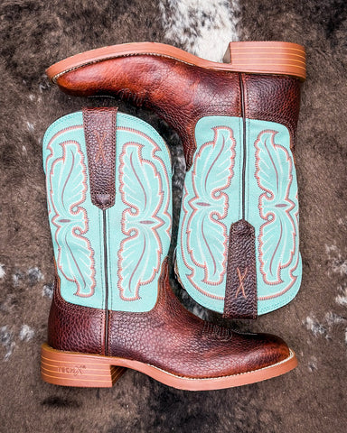 Turquoise and brown cowboy boots on a textured surface