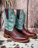 Turquoise and brown cowboy boots on a textured surface