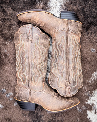 Brown cowboy boots on a textured surface