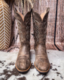 Brown cowboy boots on a textured surface
