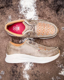 Pair of brown leather shoes with white soles on a textured brown background