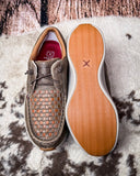 Pair of brown casual shoes with woven pattern on a textured surface
