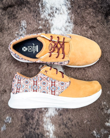 Twisted X Feather X sneaker on a textured background